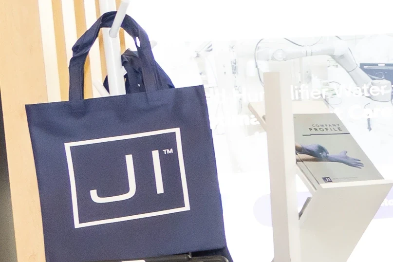 Branded material on location · the tote connects the exhibition identity with a useful take away item. Archive photograph; photographer unconfirmed.