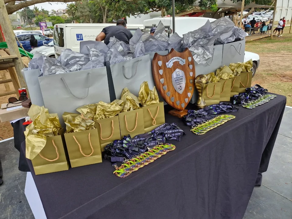 The awards table prepared with Kick for a Kid medals, a shield, trophy and gift bags.