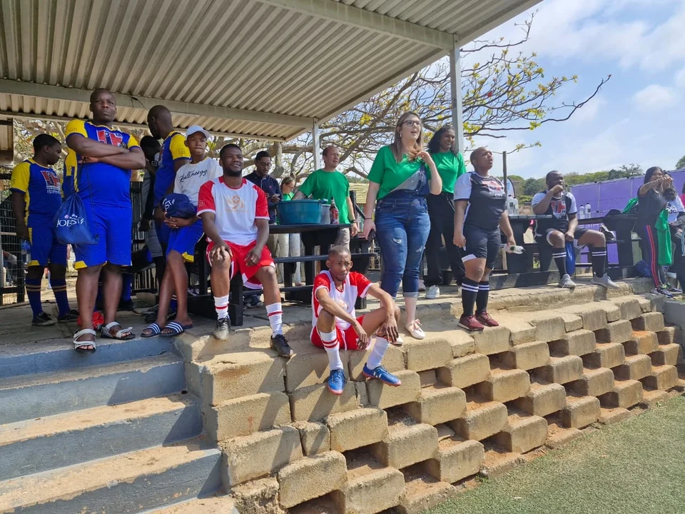 Hospital teams and supporters watching the tournament from the spectator area.