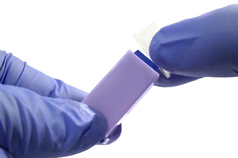 Edited close up of gloved hands and the lancet cap