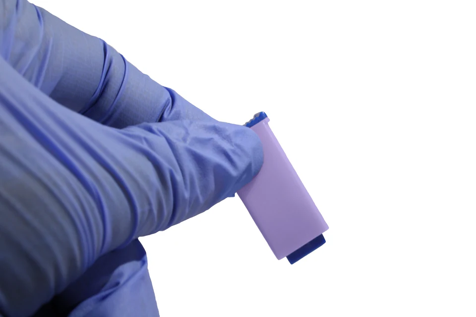 Edited close up of a gloved hand holding the lancet
