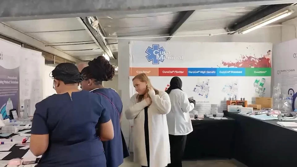Visitors and the event team at a product display with branded backdrop.